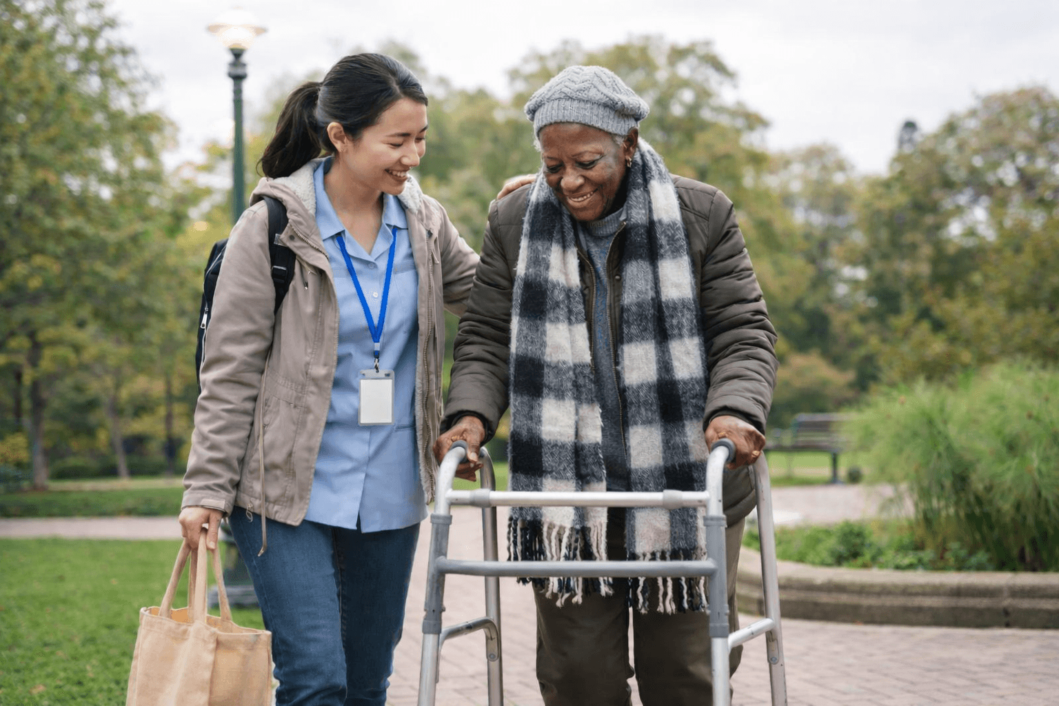 Caregiver with elderly person walking outside